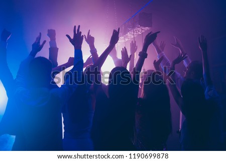 Fans rest, relax, chill waving raised hands cheering in night club having fun, carefree, careless mood