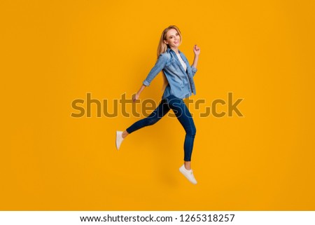 Close up side profile full length body size photo of attractive active cheer her lady jumping high going straight ready for sale wearing casual jeans denim shirt isolated on yellow bright background