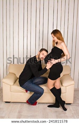 man put his ear to the belly of his pregnant wife and listening to his unborn child