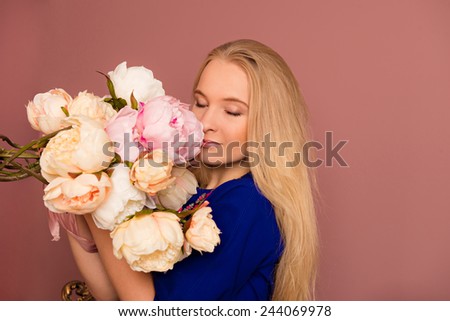 girl holding a bouquet of peony. girl smelling a fragrance peonies