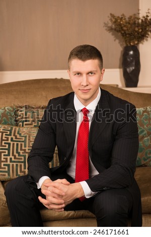 Thoughtful businessman. thoughtful young man in formal wear holding hand on chin and smiling