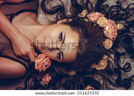 charming girl with a flowers. young woman has a beautiful face. girl lying with her long hair