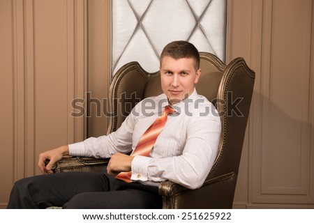 Thoughtful businessman in chic interior. thoughtful young man in a business suit sitting on the armchair