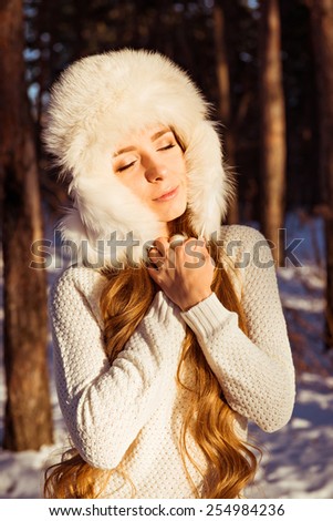 girl enjoying the sunshine in the winter forest