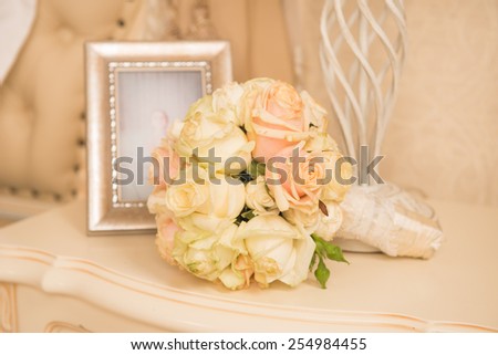 bridal bouquet lying on a bedstand near a photo in a frame