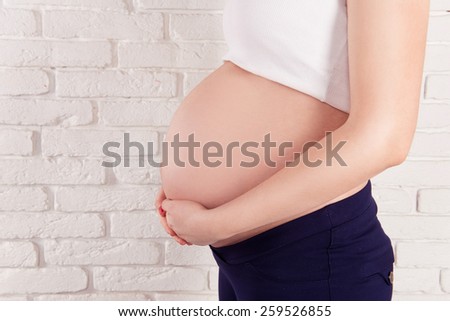 pregnant woman hugging her tummy