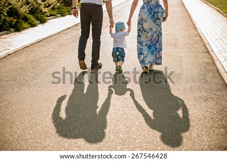 Family walking with baby. image of family\'s shadows