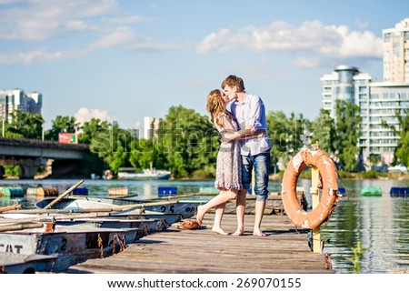 couple in love are on a wooden pier near the boat. Man and woman kiss on the dock