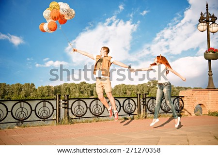 man and woman in love. lovers fly holding on balloons
