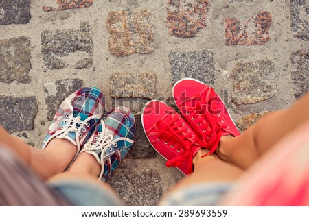 top view of a two pairs of sneakers shoes walking on paving ston