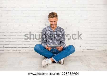 man sitting on the floor with digital tablet