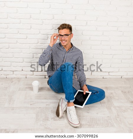 man sitting on the floor with digital tablet