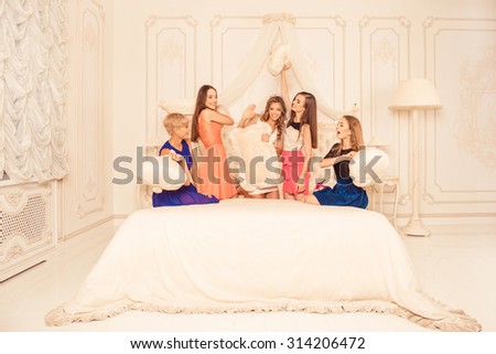 cheerful girls staged a pillow fight on the bed