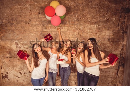 Happy pretty girls holding birthday cake, balloons and presents