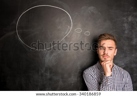 Young  man against the background of chalkboard thinking about the issue