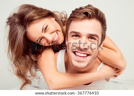 Happy cute girl in love at home embracing boyfriend