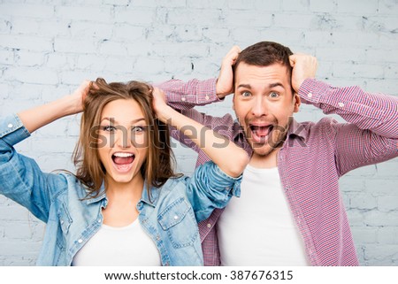 Close up photo of angry man and woman touching their heads