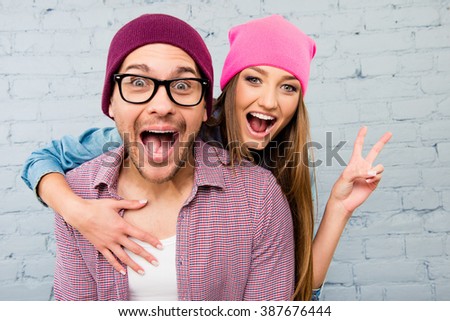 Portrait of two happy  lovers in caps huging and screaming