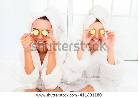 Two pretty women with cucumbers on eyes and towel on their heads