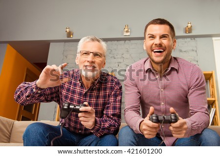 Two happy friends playing video games at home