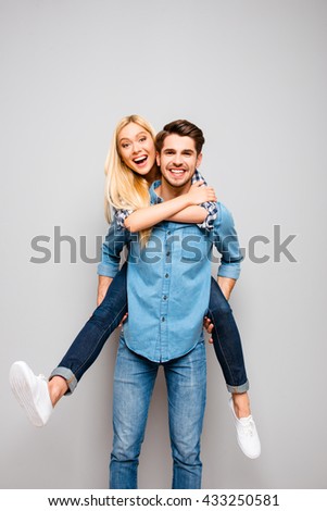 Cute couple in love traveling. Happy man carrying his joyful girlfriend on the back
