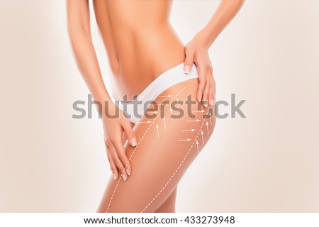 Beautiful slim fit woman touching her body with arrows isolated on beige  background