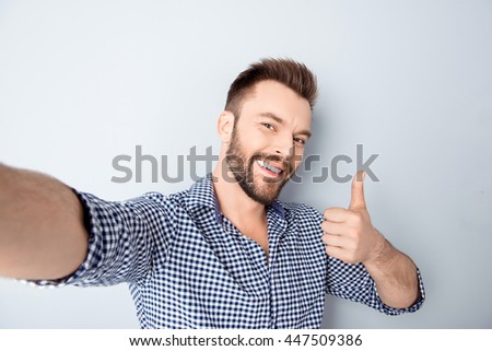 Happy man making selfie and showing thumb up