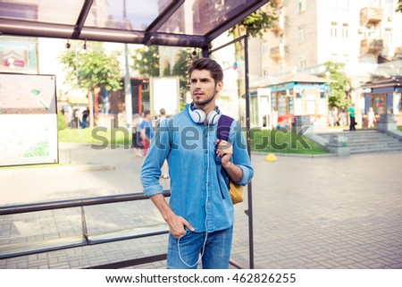 handsome young man  waiting his bus at bus stop