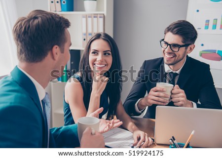 Cheerful office workers  discussing their project over cup of tea