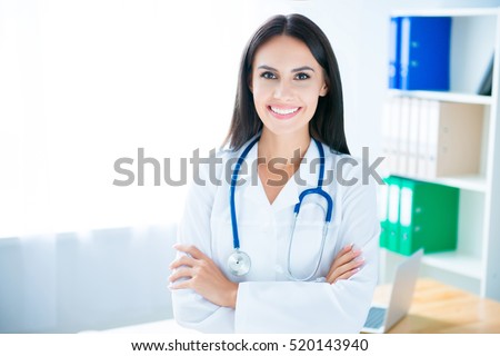 Portrait of cheerful happy doctor in hospital with crossed hands