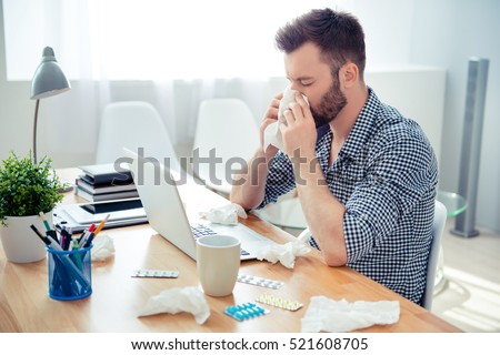 businessman having cold in the head and sitting at workplace
