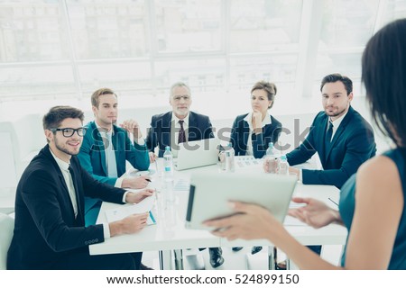 Businessmen and women  in conference room on presentation of new product