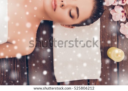 Half face portrait of young woman in sauna with snowflakes.