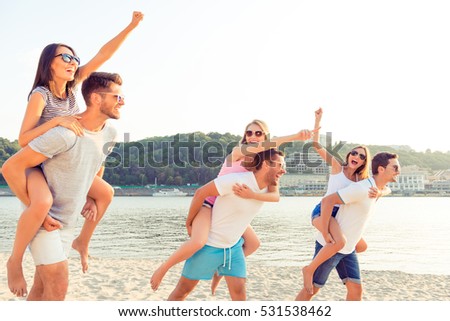 Cheerful couples enjoying weekend and having fun near the river