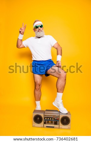 Crazy aged serious athlete pensioner grandpa in eyewear, sneakers, sexy shorts, with bass clipping ghetto blaster recorder. Old school, swag, fooling around, gym, workout, technology