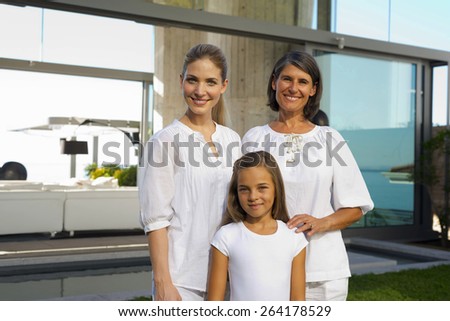 Portrait of grandmother, mother and daughter in the backyard of a luxury house.