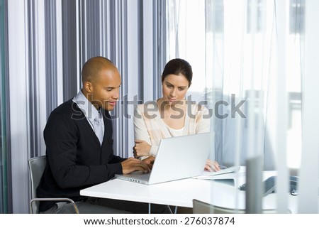 Male and female business executives working together in office.