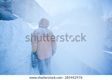 Man in yellow jacket with snow removal machine walks on a snowy valley in clouds of ice spray. Snowy winter illustration