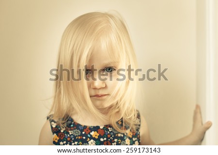 Adorable little girl looking directly at the camera. The face is covered with long hair. straight look.
