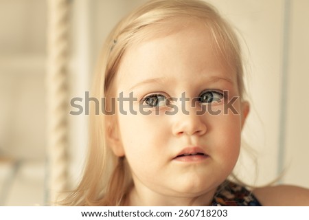Adorable little girl in her room. Thoughtful, pensive face