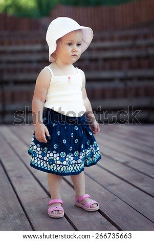 Adorable little girl staying still. Sad face. Wood stage. Special toned colors. Wood background.