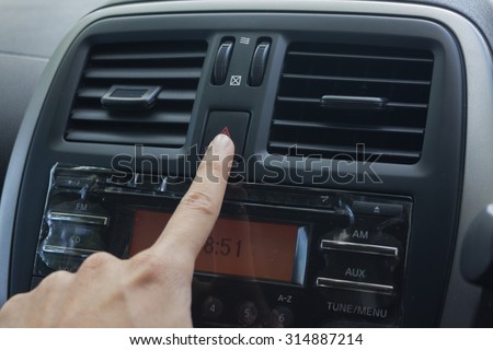 man hand use the signal switch. Car interior detail with blue light.