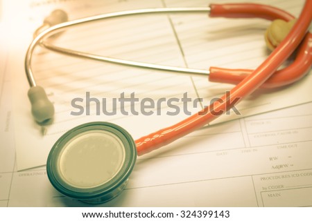 Vintage closeup stethoscope on medical paper background