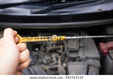 man hand check and fill engine oil in engine with open hood show parts in side