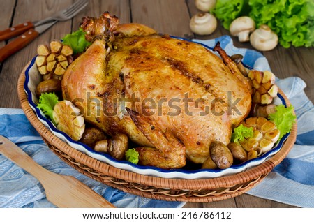 Whole roasted chicken stuffed with buckwheat and mushrooms on wooden table