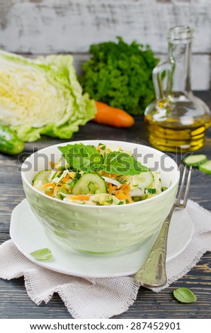 Cabbage salad with cucumber. Salad and vegetables on wooden table