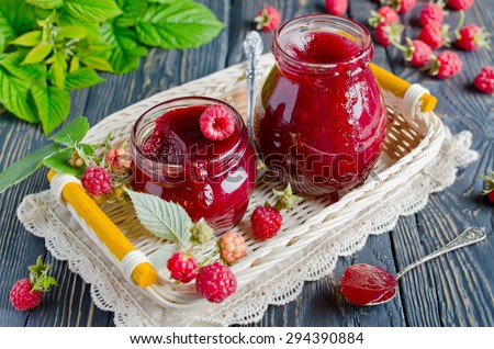 Raspberry jam ( marmalade ) and fresh raspberry on a rustic wooden table.Selective focus