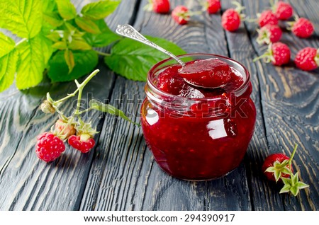 Raspberry jam ( marmalade ) and fresh raspberry on a rustic wooden table.Selective focus