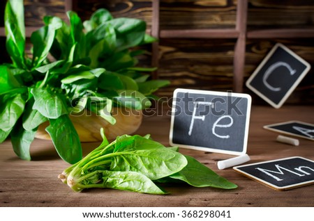 Spinach rich in vitamin C, manganese and iron on a dark background. Spinach is an annual vegetable is a herbaceous plant of the family Chenopodiaceae.