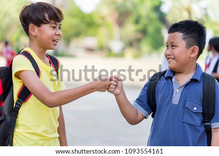 Fist Bump Friends Deal Partner Touch Pair Hands. Elementary students greet each other Trust in Team Giving Fist Bump to Greeting Start up Back to School or Say goodbye on weekends. education concept